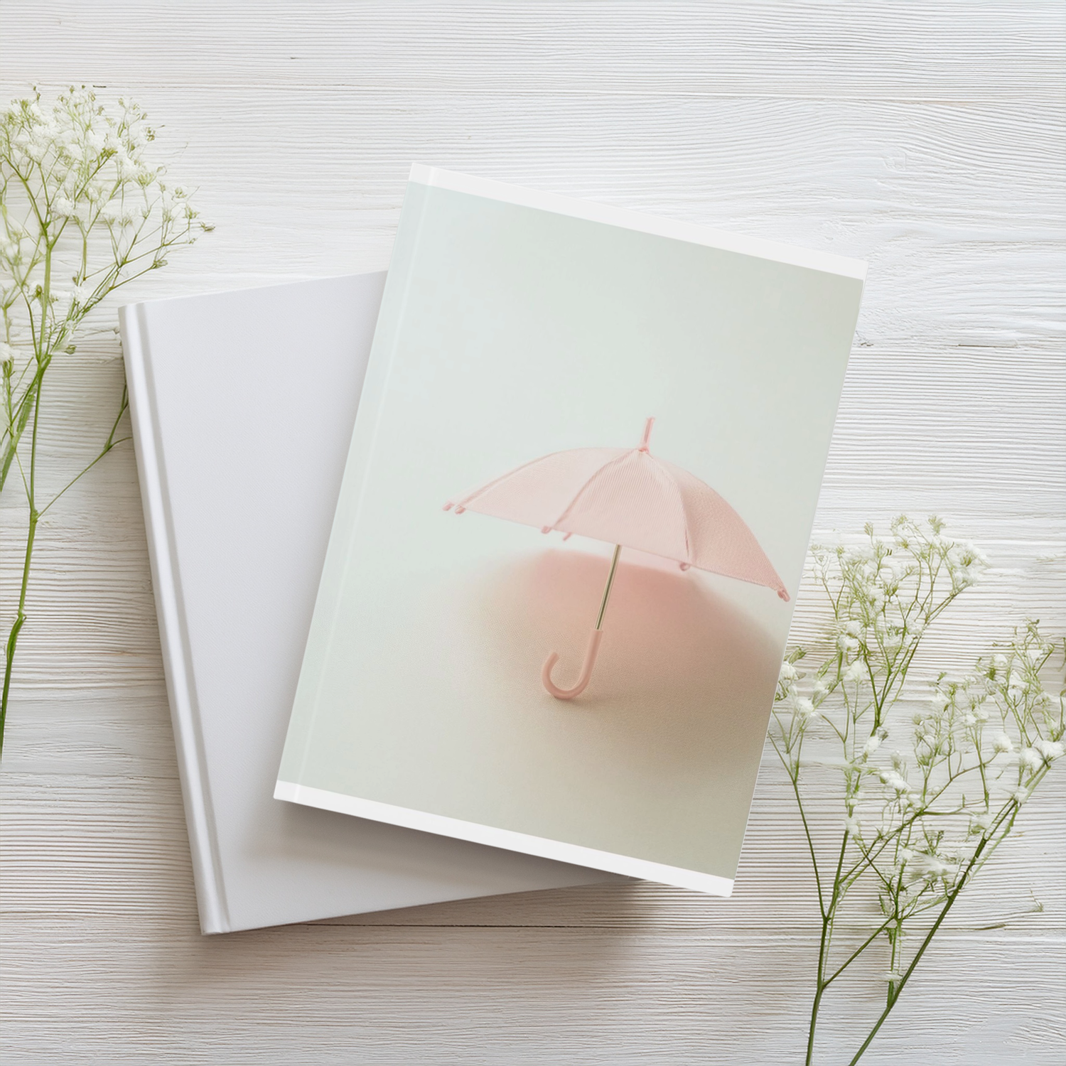 Pale pink vintage umbrella aesthetic A5 journal styled on a wooden table with a handful of wild flowers