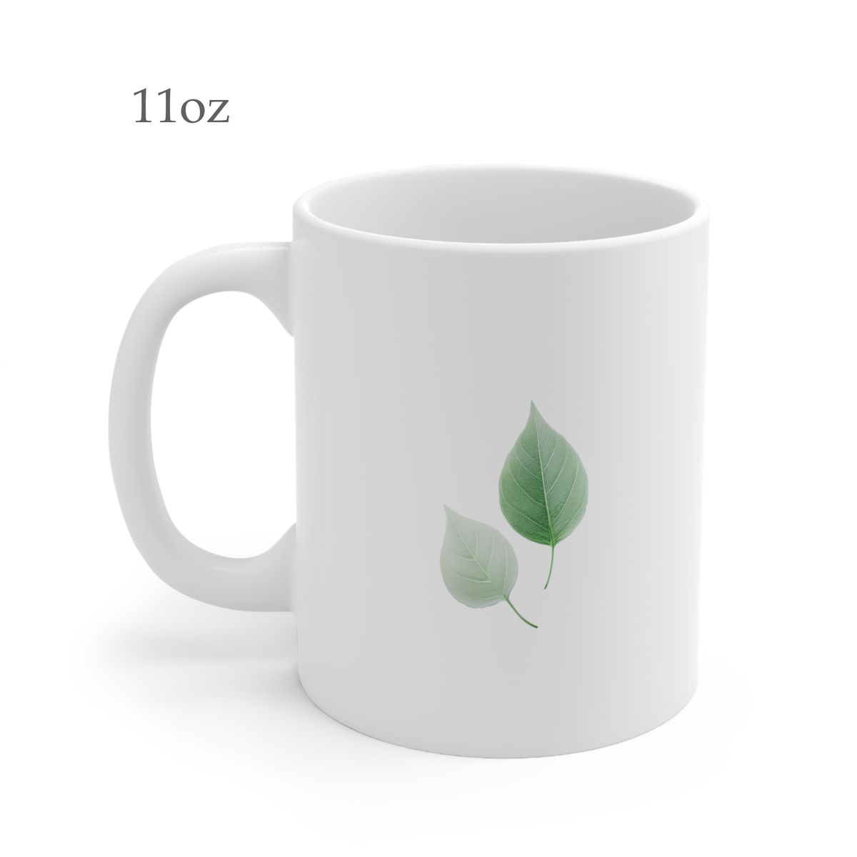 Left side view of white ceramic autumn leaf mug, 11oz size, showing two green leaves design and handle