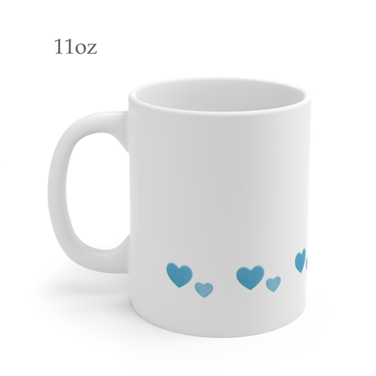 Left side view of white ceramic blue heart mug, 11oz size, showing handle. The blue hearts are in two sizes in different shades of blue.