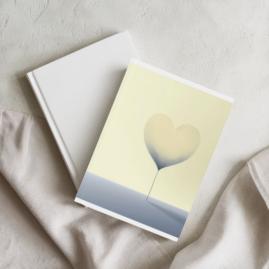Yellow and blue floating heart aesthetic A5 journal, styled stacked on book on linen