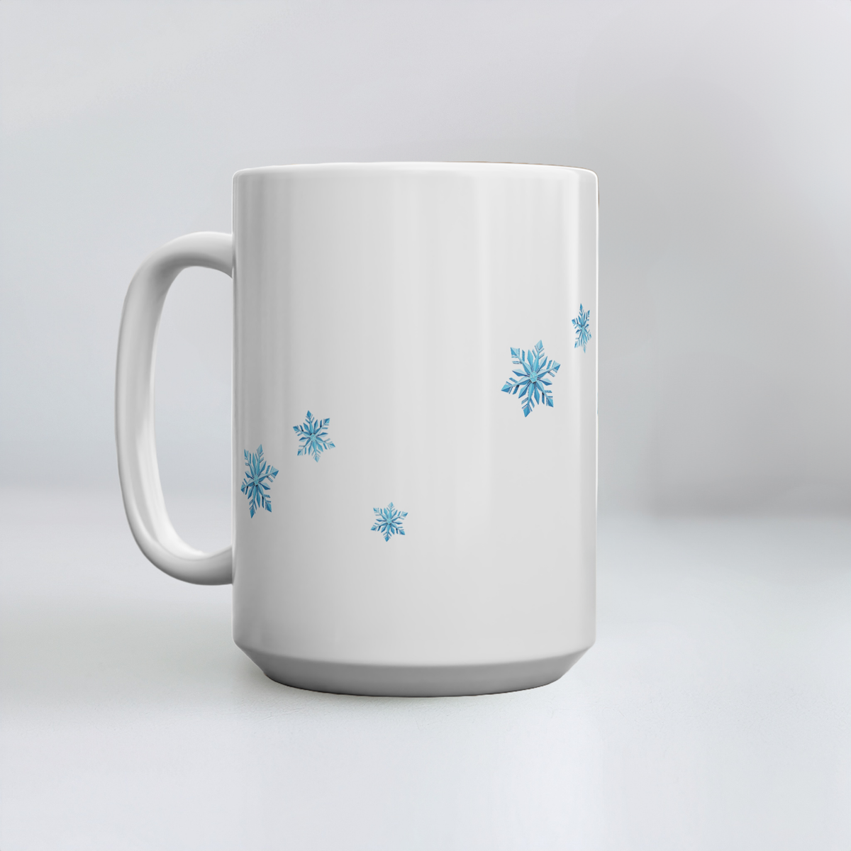 A 15oz white ceramic mug with a handle, decorated with several light blue snowflakes, set against a clean white background.